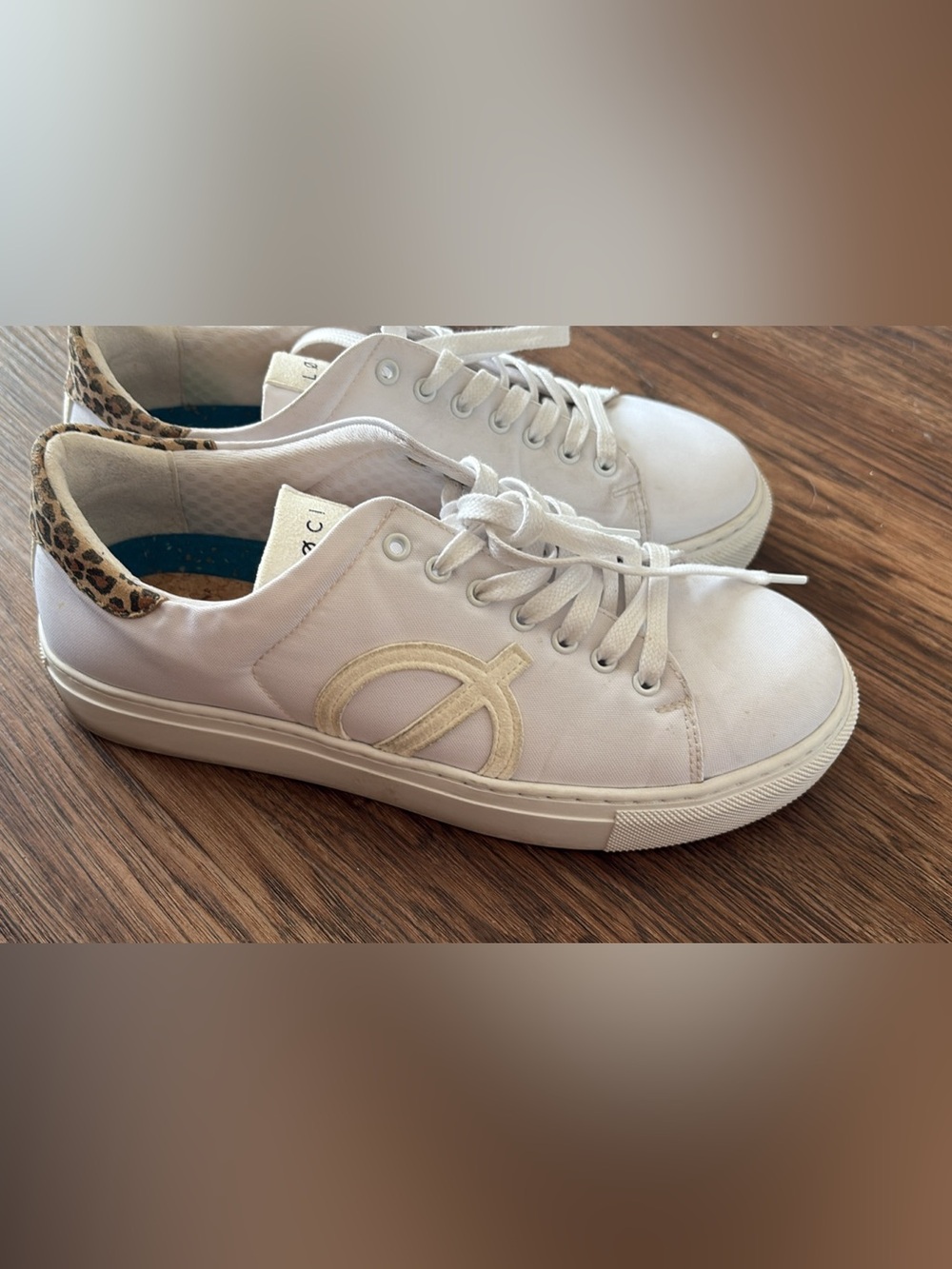 These are LØCI Nine white vegan sneakers featuring a leopard print heel accent.